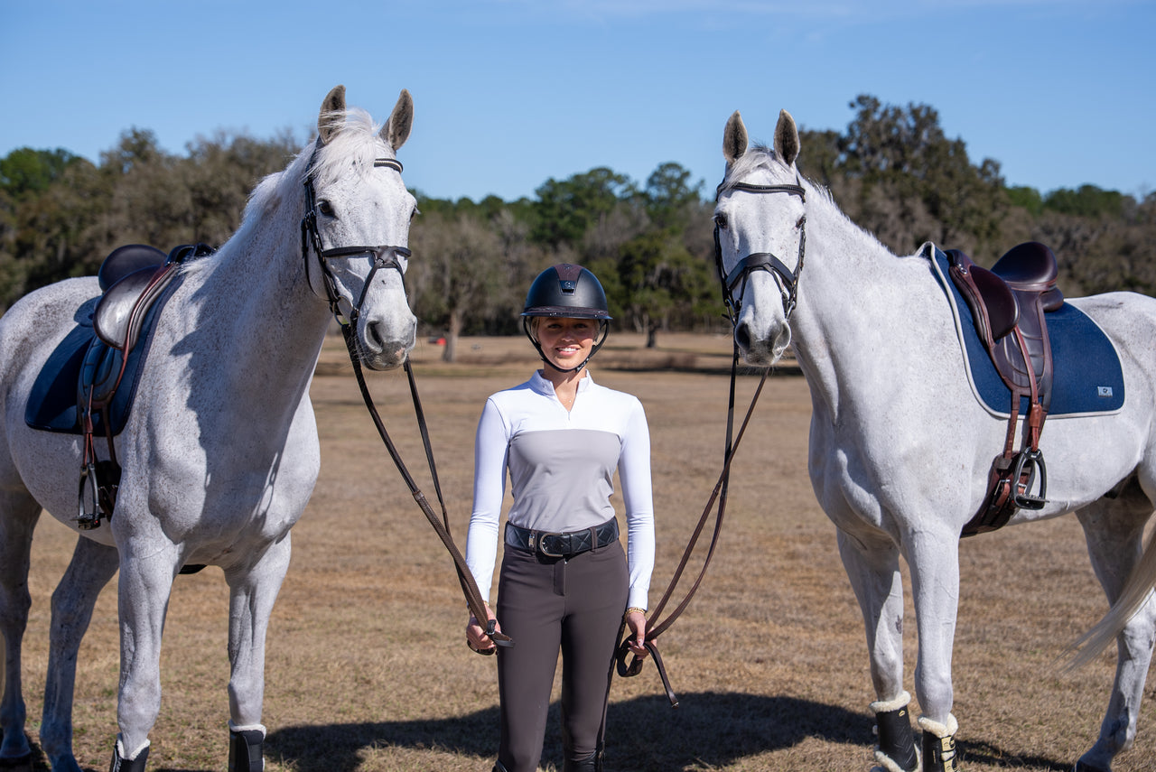 Equestrian rider with two grey show jumpers